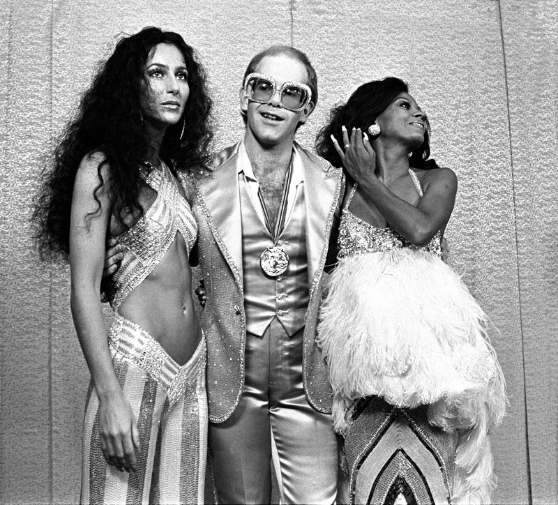 Cher, Elton John and Diana Ross at Rock Awards Santa Monica Civic Auditorium 1975; Photo Mark SullivanContour by Getty Images.jpg Cher, Elton John, Diana Ross Diva Exhibitions Victoria and Albert 